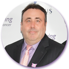A man in a suit and tie stands in front of a sign that says ing on it