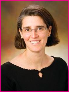 A woman wearing glasses and a black shirt smiles for the camera