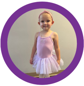 A little girl is wearing a pink leotard and white tutu