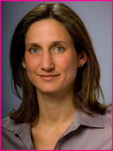 A woman in a purple shirt is smiling for the camera