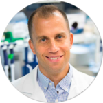 A man in a lab coat is smiling in a circle.