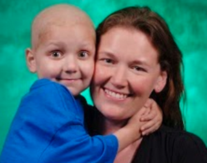 A woman is holding a child with cancer in her arms