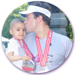 A man with a medal around his neck holds a little girl