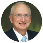 A man in a suit and tie is smiling in a circle.