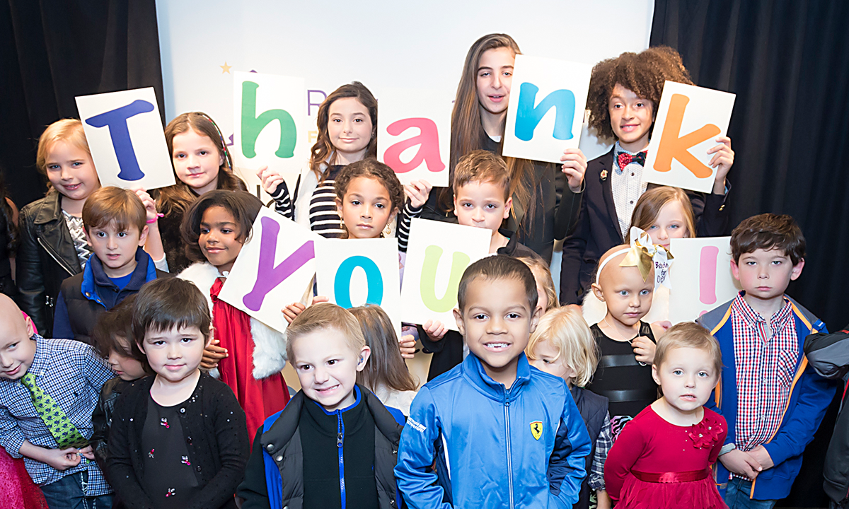 A group of children are holding up signs that say thank you
