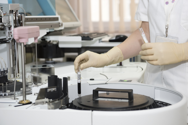 A nurse is working on a machine in a laboratory.