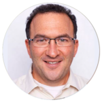 A man wearing glasses and a white shirt is smiling in a circle.