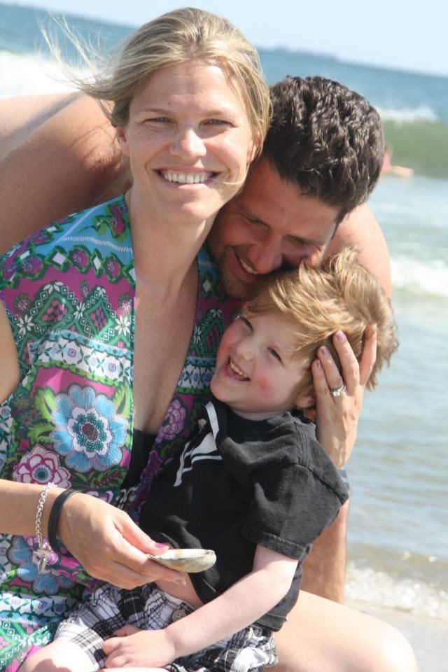 A family is posing for a picture on the beach.