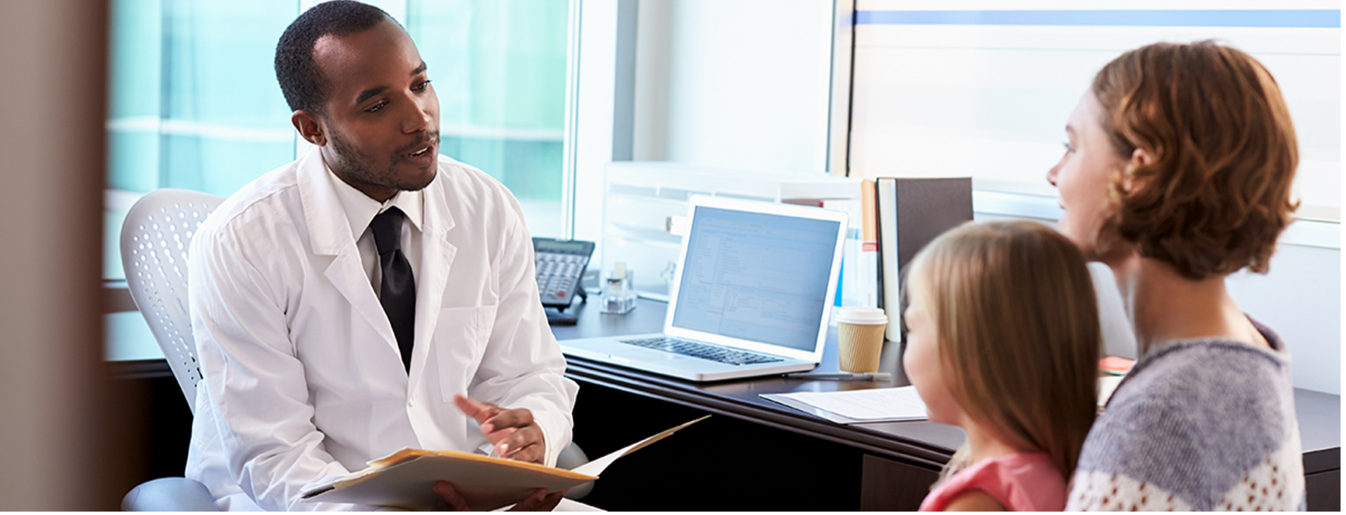 Physician speaking with parents and child