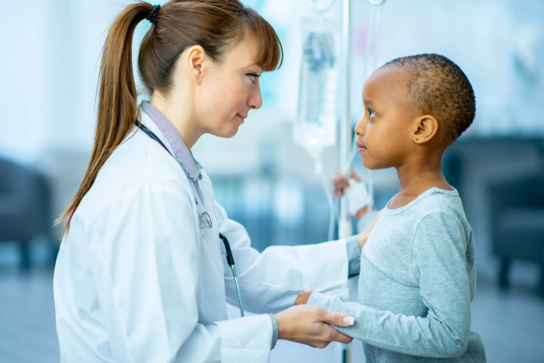 A doctor is holding the hand of a little girl in a hospital.