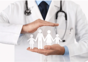 A doctor is holding a paper cut out of a family