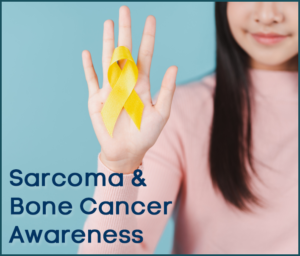 A woman is holding a yellow ribbon in her hand for sarcoma and bone cancer awareness
