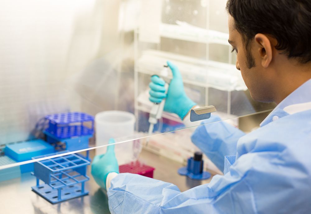 A man is using a pipette in a laboratory.