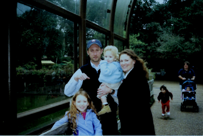 A family posing for a picture in front of a glass building
