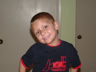 A young boy wearing a black shirt with a red tractor on it