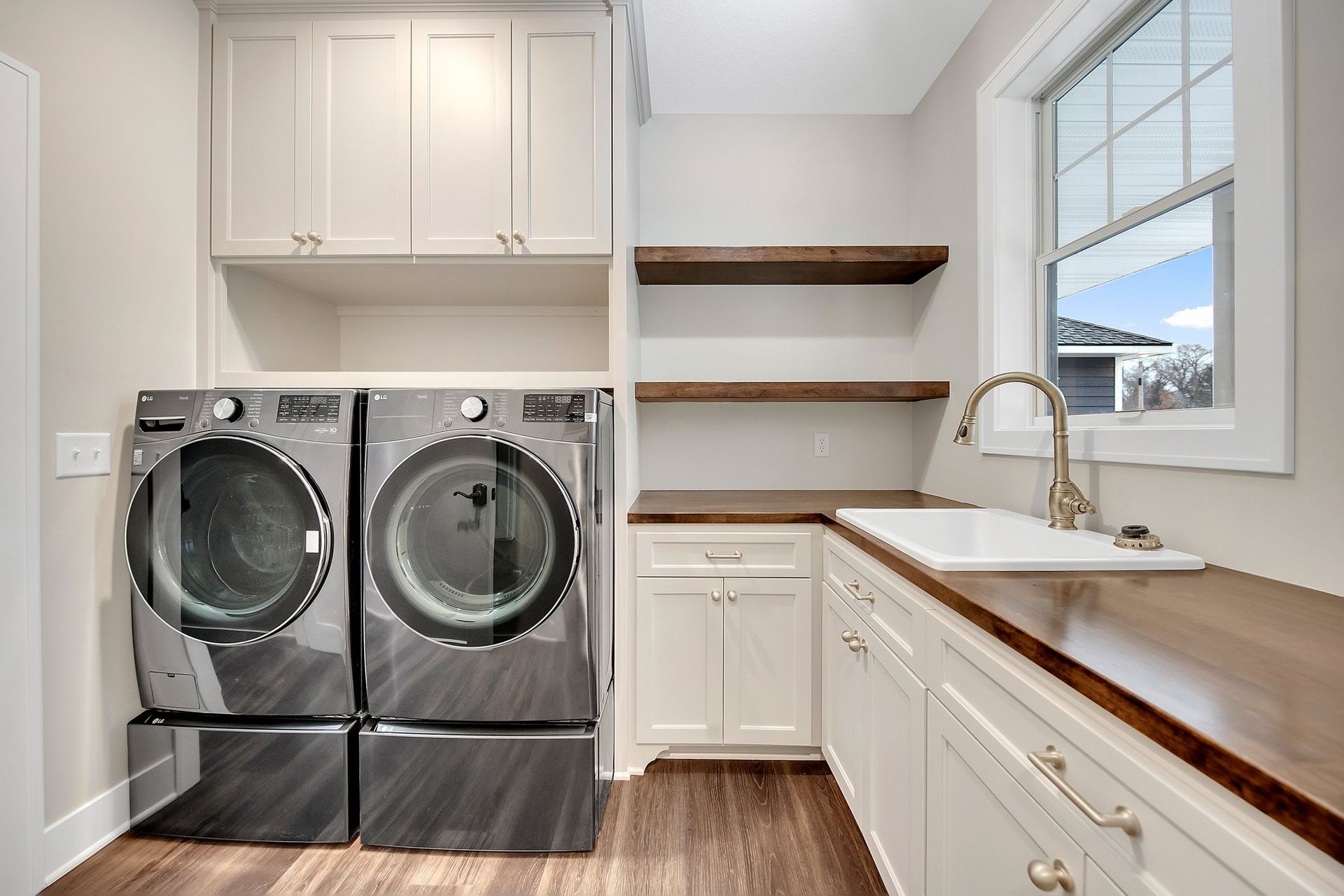 A laundry room with a washer and dryer and a sink.