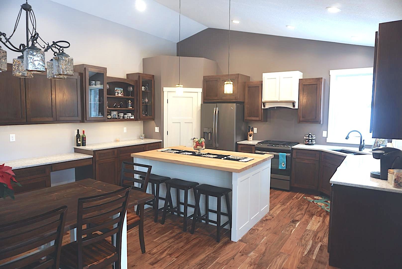 A kitchen with a large island in the middle and a table and chairs.