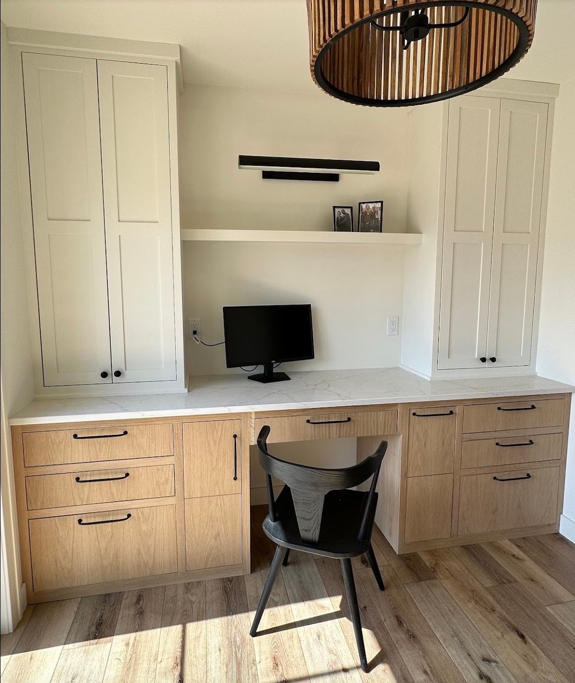 There is a desk with a computer on it and a chair.