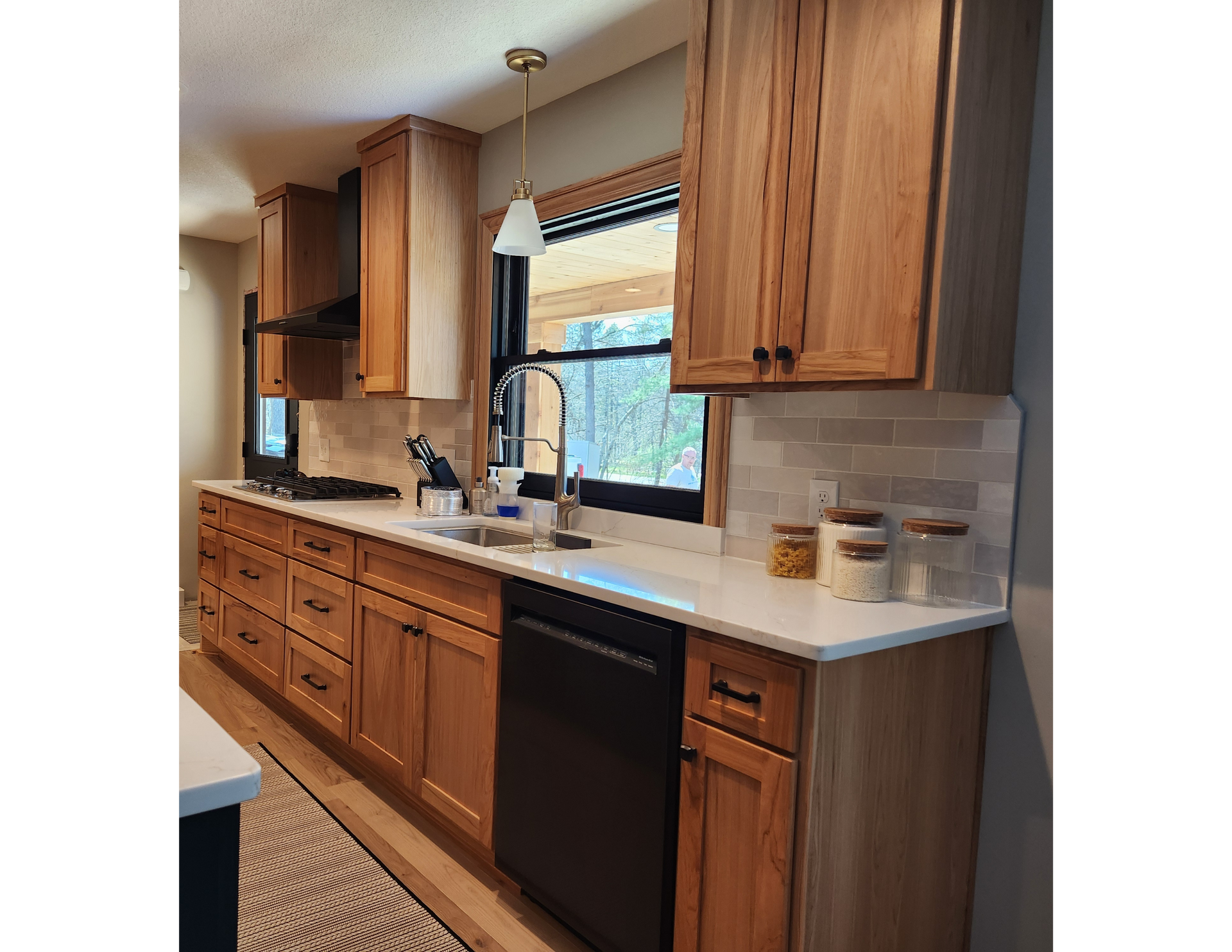 A kitchen with wooden cabinets , a sink , and a dishwasher.