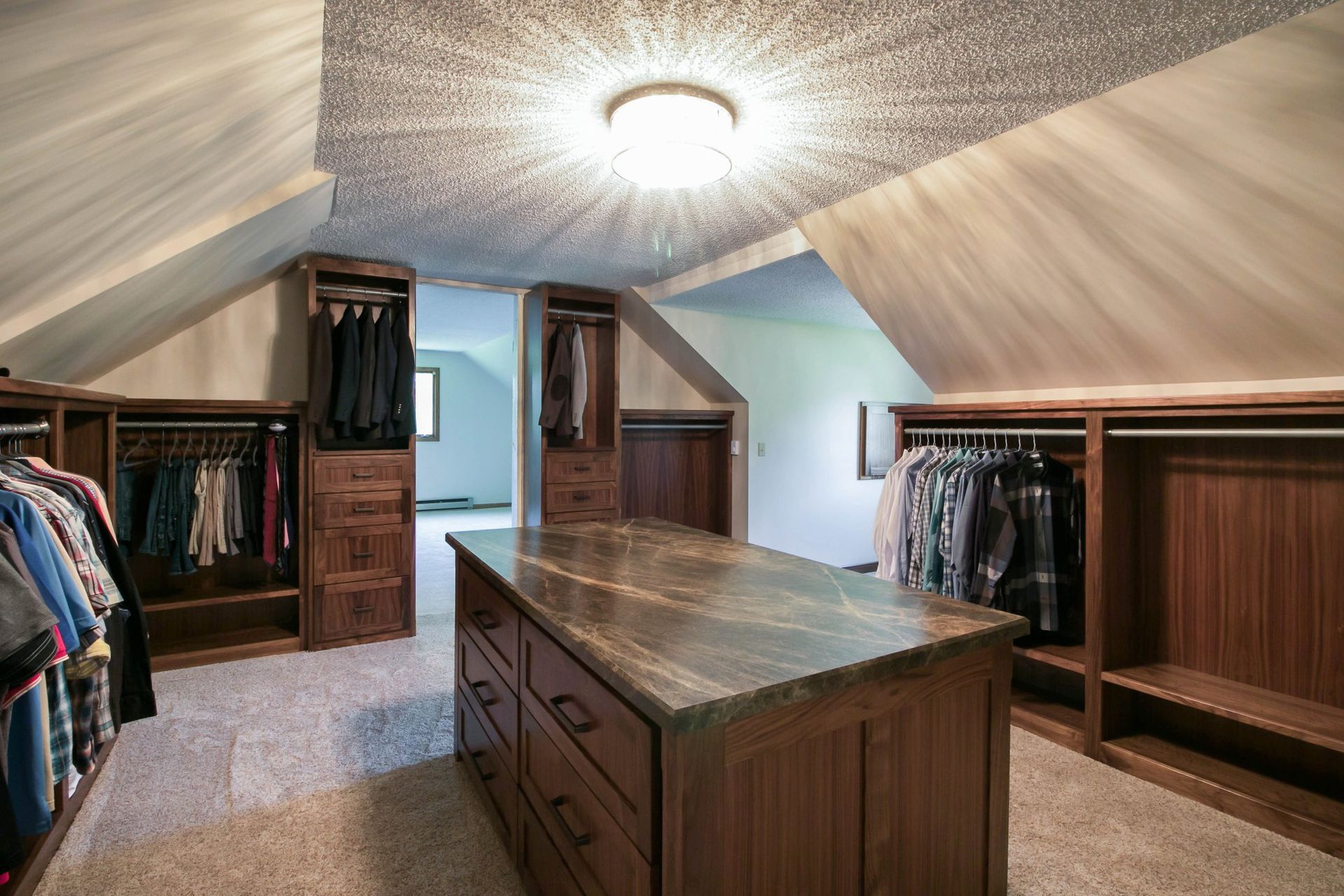 A walk in closet with a large island in the middle