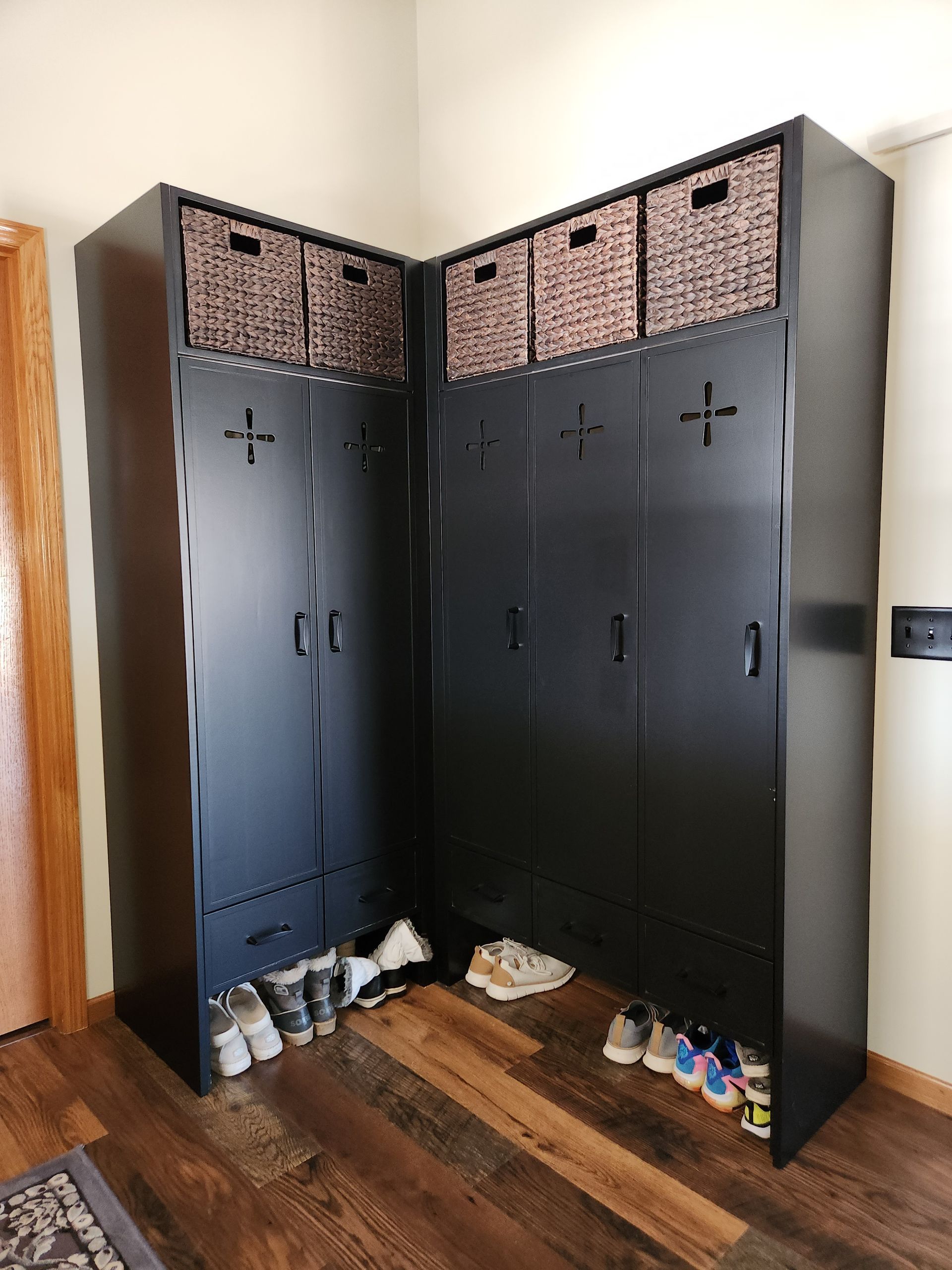 A corner of a room with a closet and a bunch of shoes on the floor.