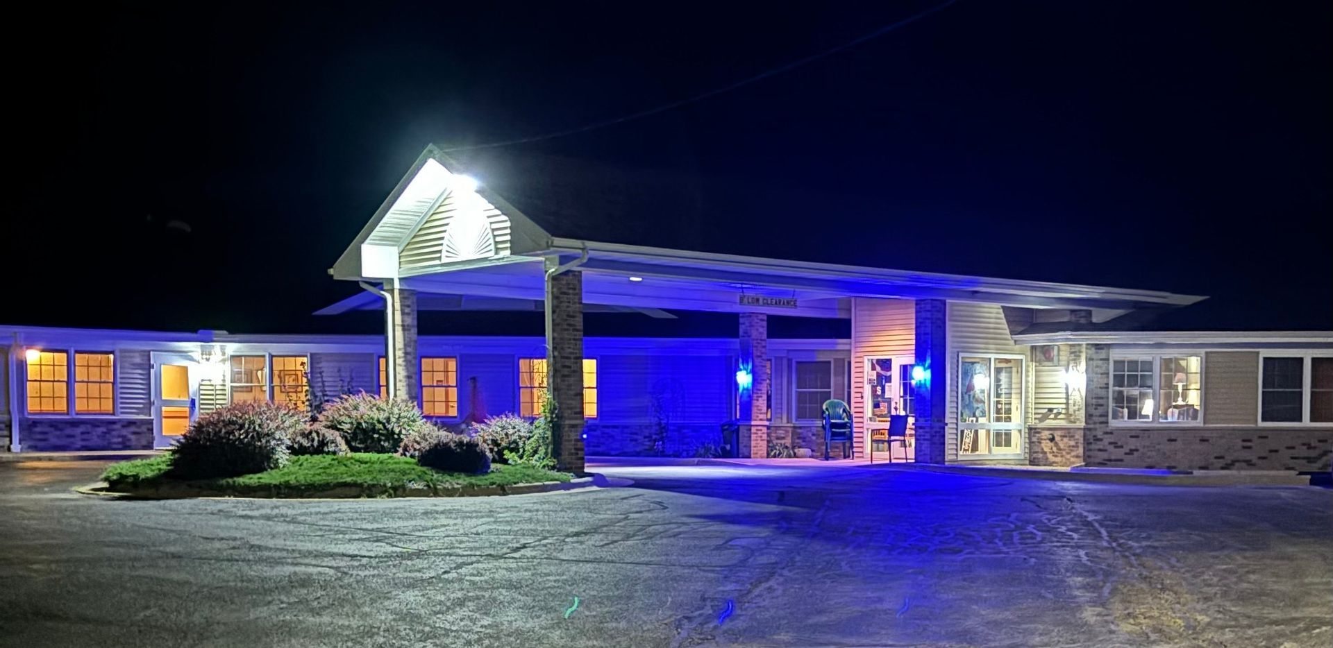 A motel is lit up at night with blue lights.