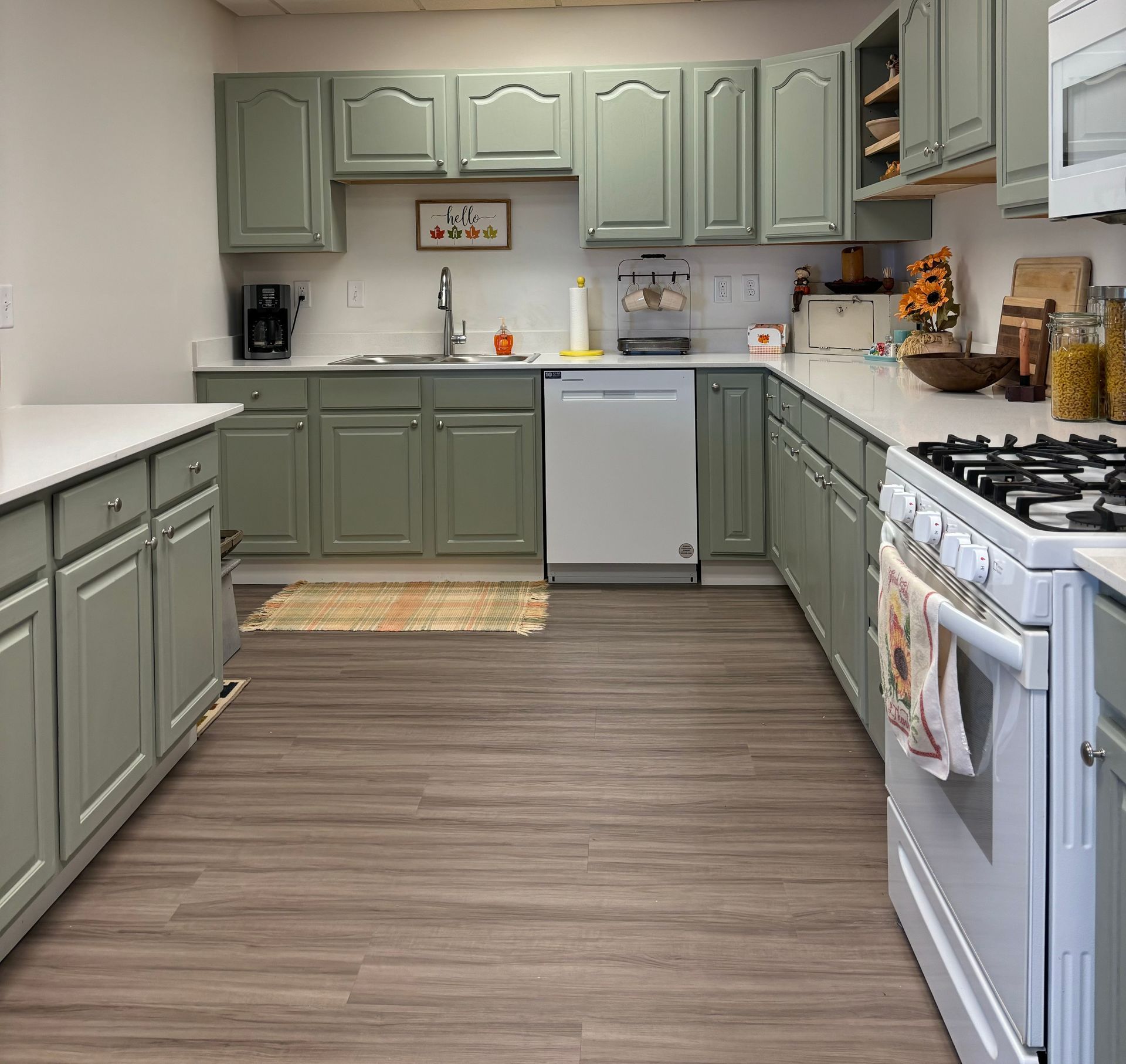 A kitchen with green cabinets and a white stove
