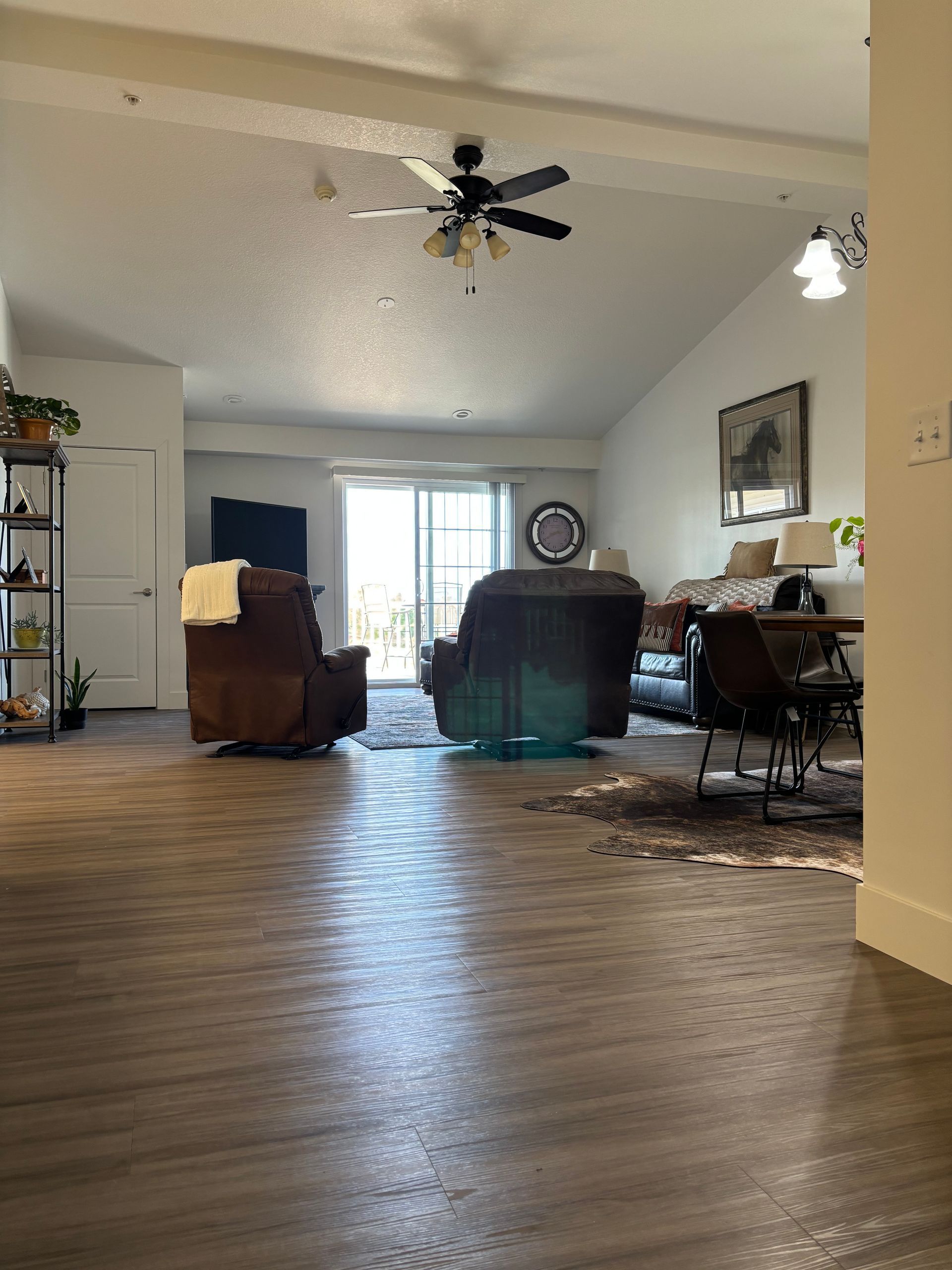 A living room with hardwood floors and a ceiling fan.