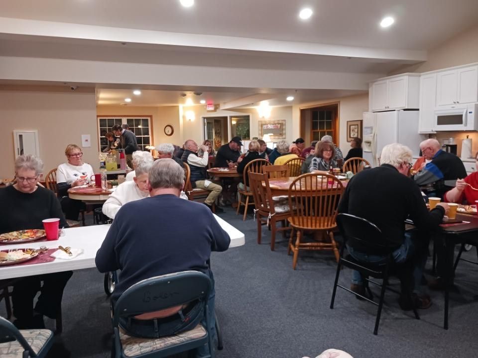 A group of people are sitting at tables in a large room
