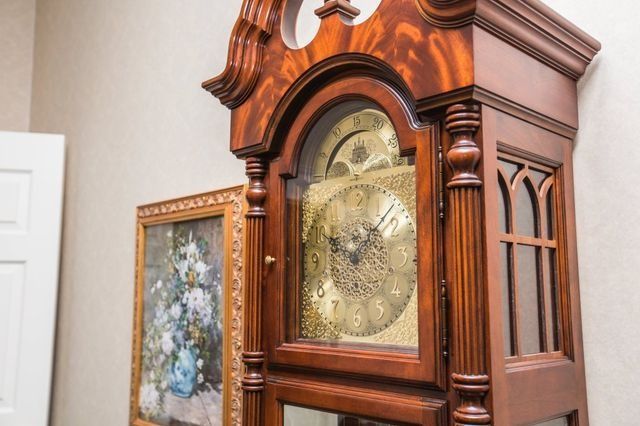 Grandfather clock with a wooden frame and ornate face.