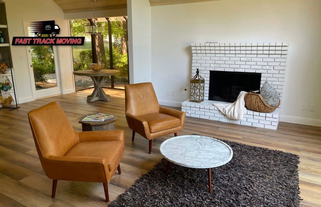 A living room with two chairs , a coffee table , and a fireplace.
