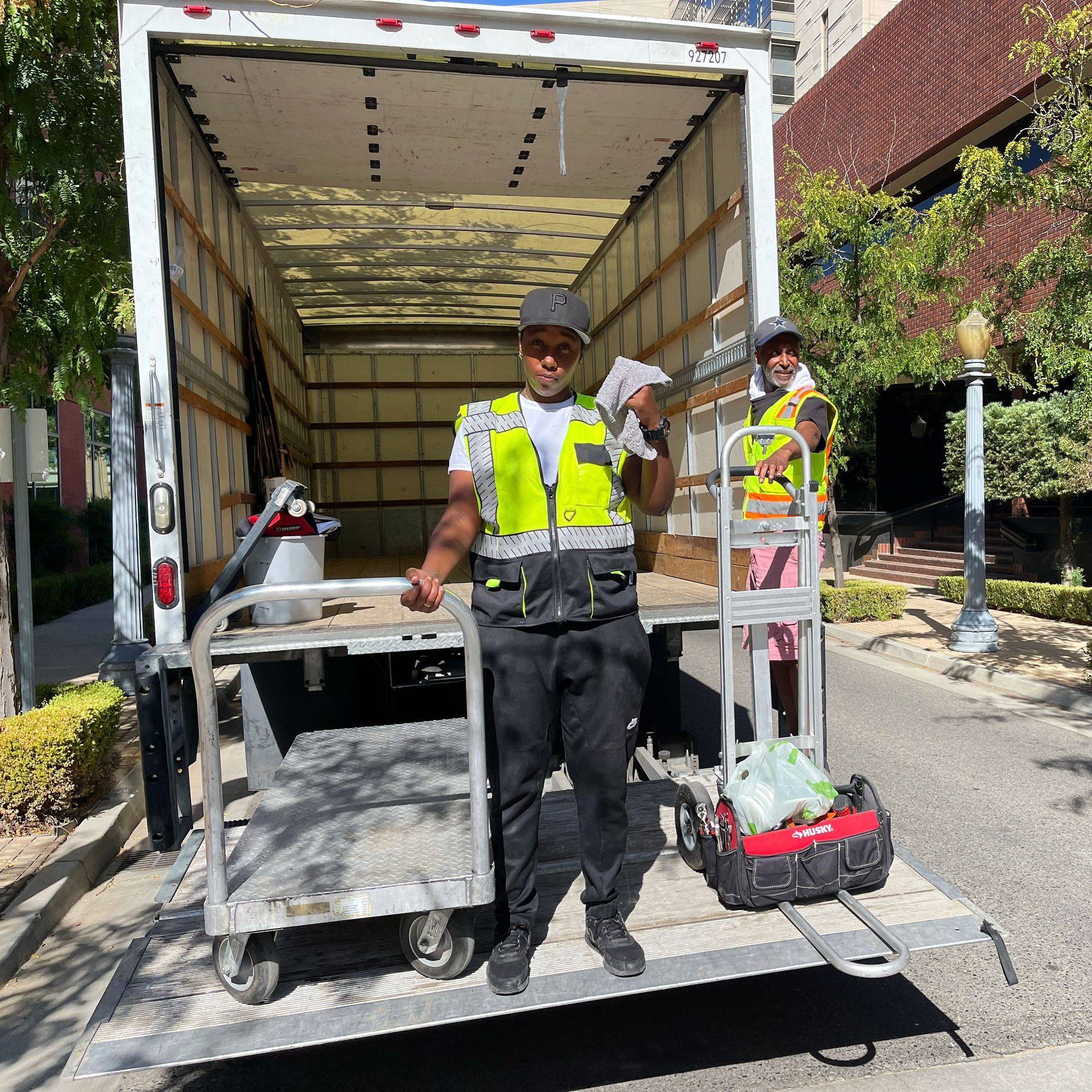 A man and a woman are standing in front of a moving truck.