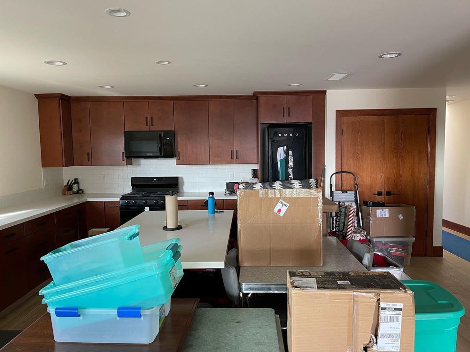 A kitchen filled with boxes and plastic containers.