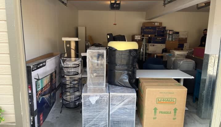 A garage filled with lots of boxes and furniture.