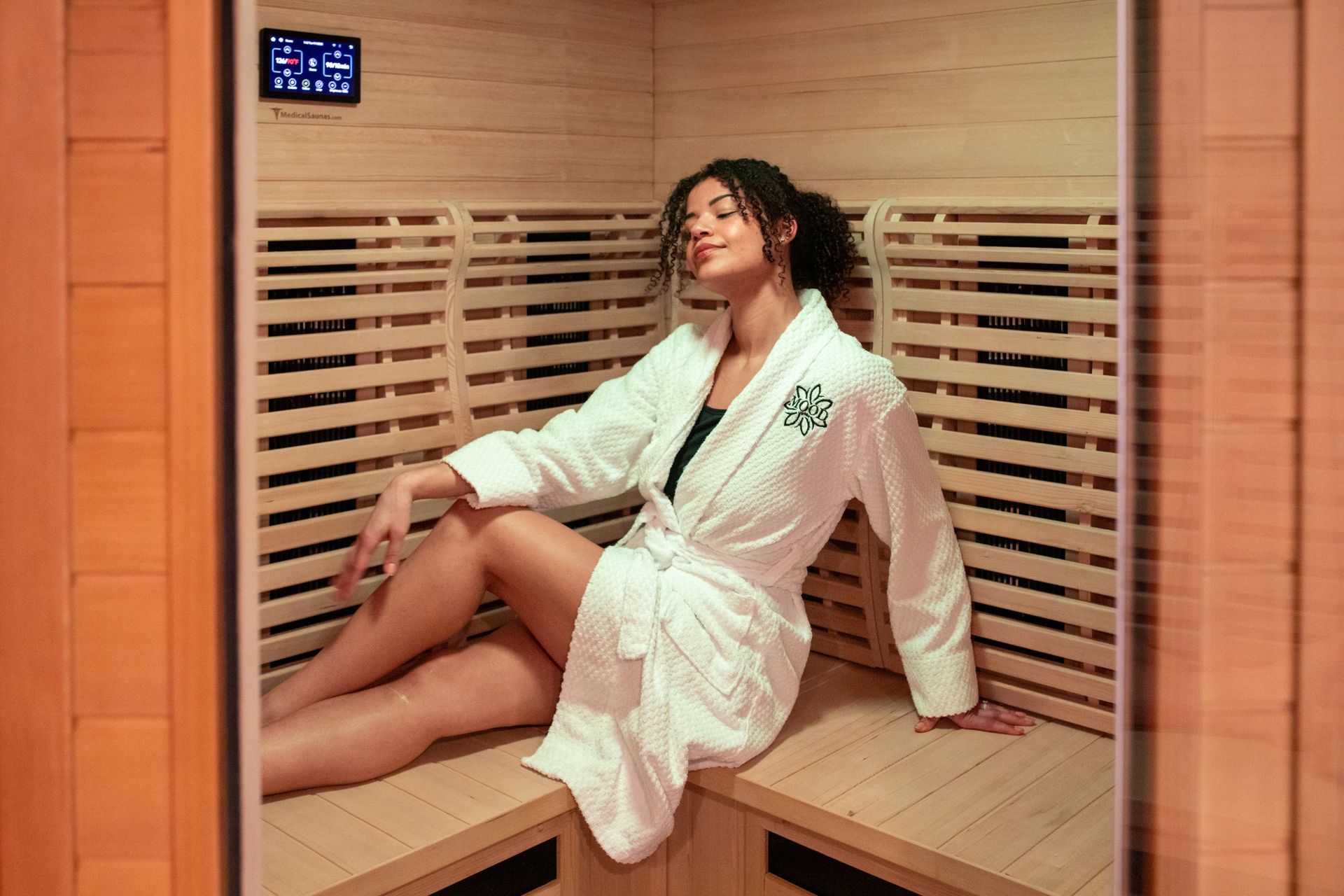 A couple relaxing in a wooden sauna, bathed in red light.