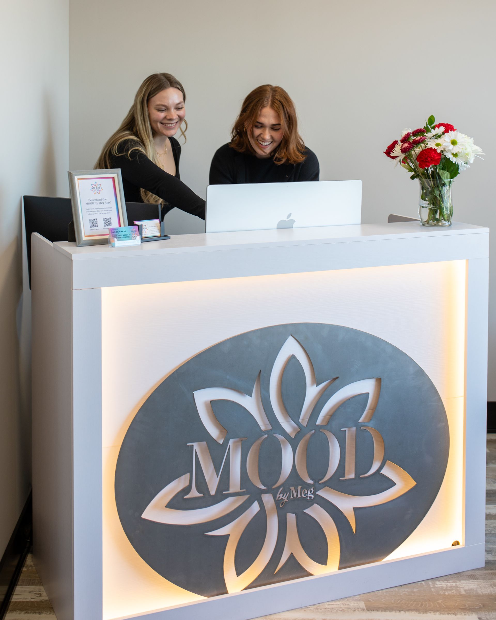 Wooden sauna interior with benches, heater with rocks, and textured stone wall.