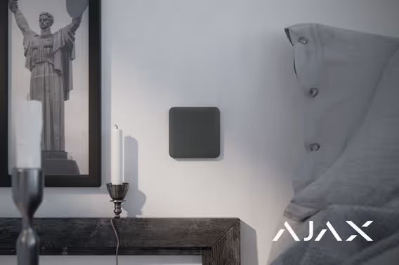 Dark Gray Square Security Device on a White Wall, Near a Framed Picture and Jacket — Cussler NQ in Airlie Beach, QLD