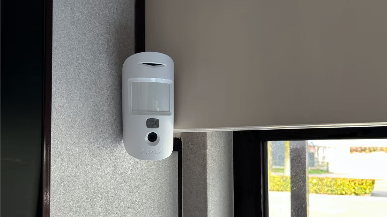 White Motion Sensor Mounted on Textured Wall Next to a Window With Closed Blinds — Cussler NQ in Cannonvale, QLD