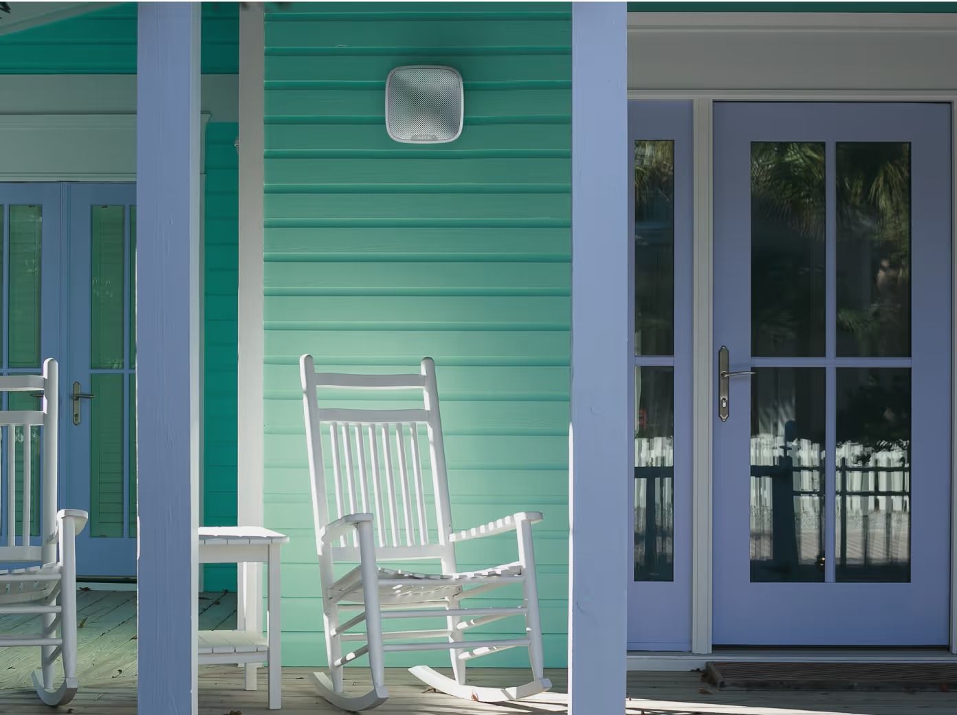 White Rocking Chair on a Porch With Teal Siding and Light Blue Doors — Cussler NQ in Proserpine, QLD