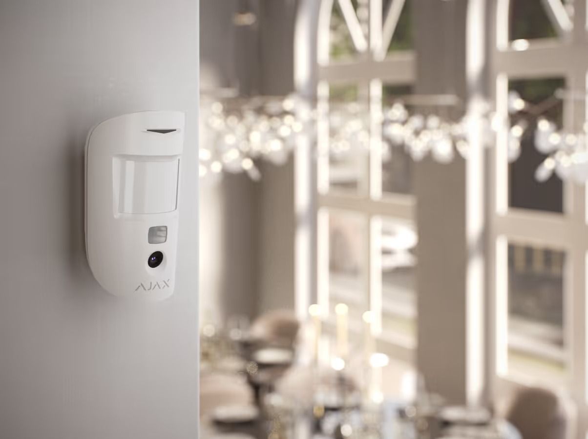 White Motion Sensor Mounted on a Gray Wall in a Bright Dining Room — Cussler NQ in Cannonvale, QLD
