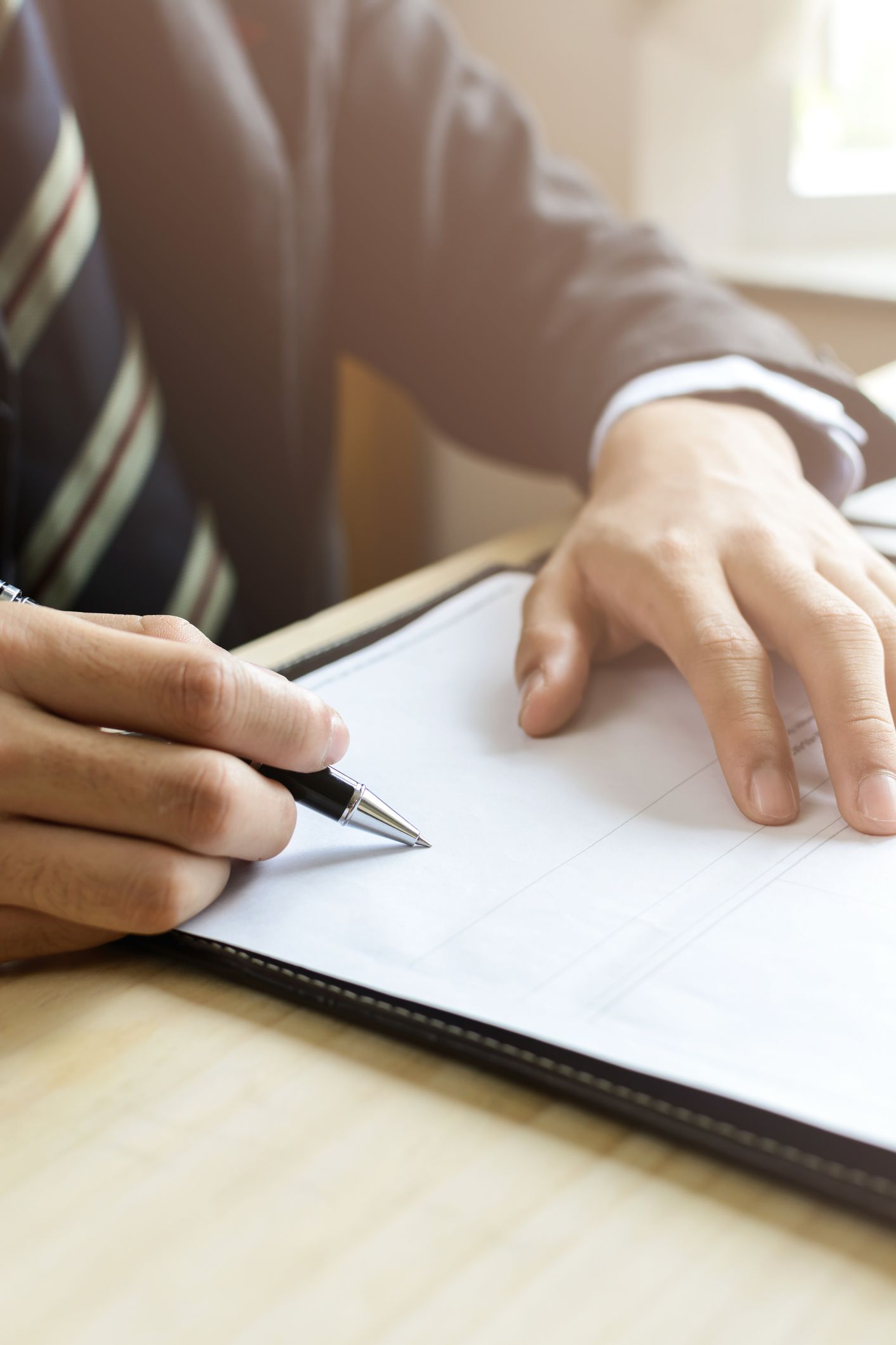 A man in a suit completing an important estate planning document