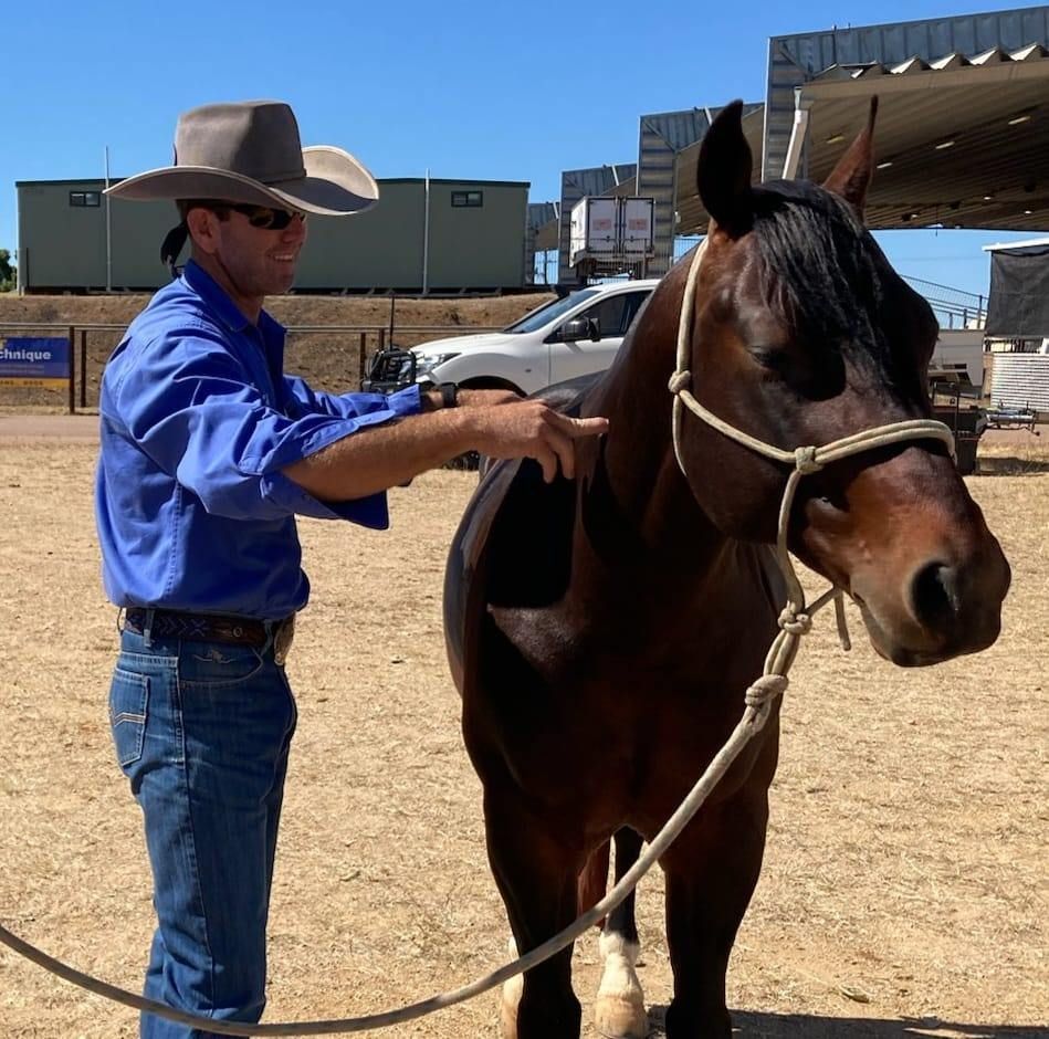 A Man In A Cowboy Hat Stands Next To A Brown Horse — Jono Battle Equine Services In Toowoomba, QLD
