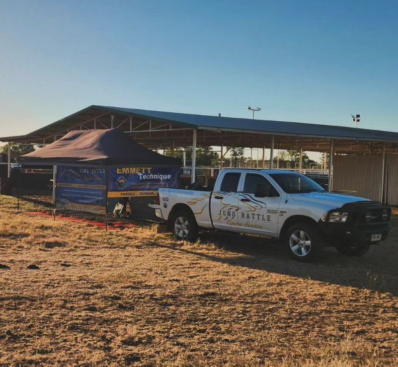 A White Truck Is Parked In A Field In Front Of A Building — Jono Battle Equine Services In Walkamin, QLD