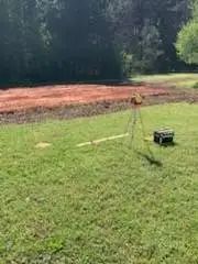A lawn mower is sitting in the middle of a lush green field.