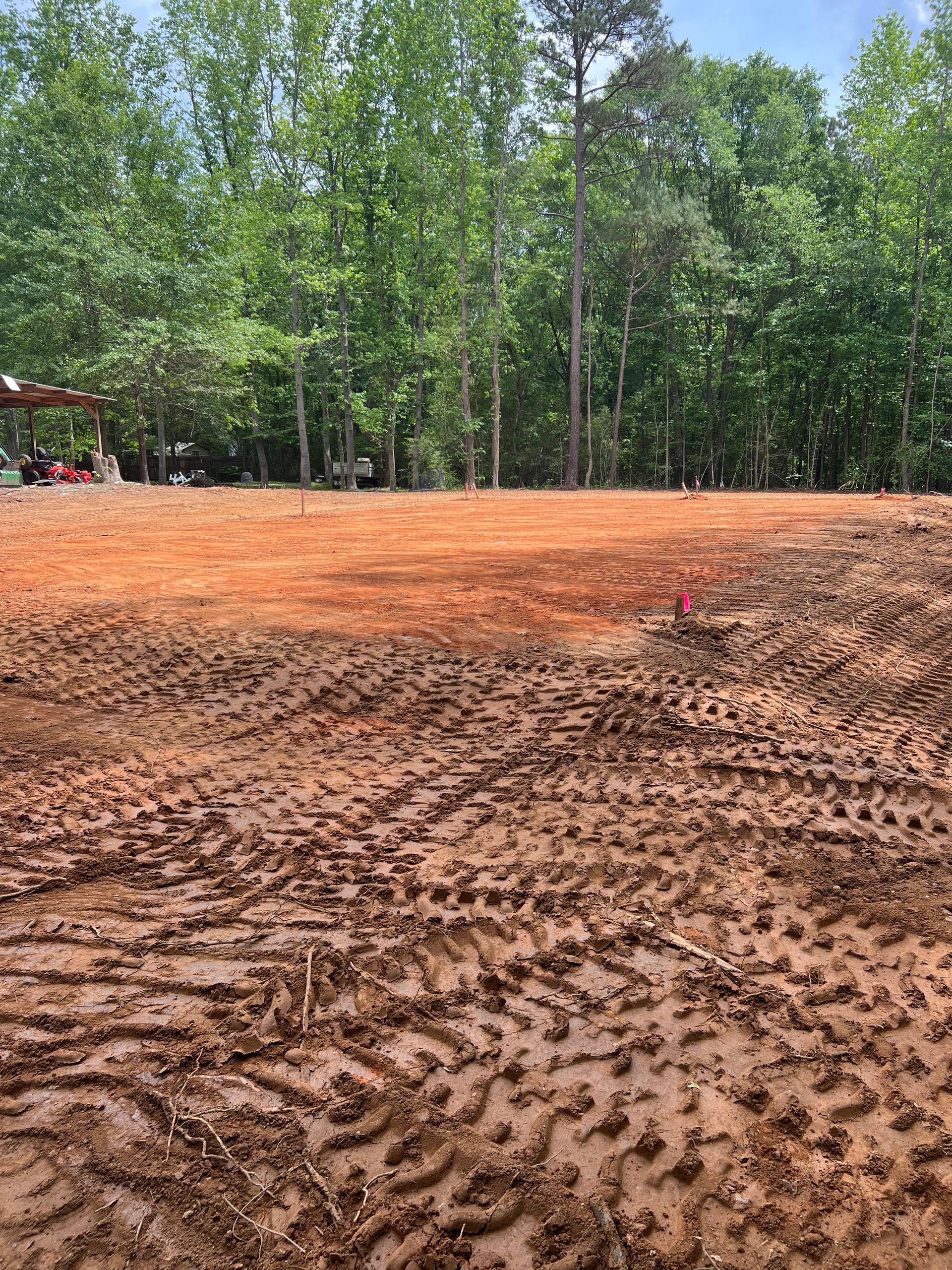 A large muddy field with trees in the background.