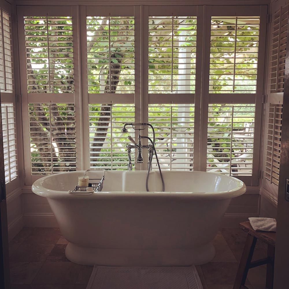 Bathroom with Bathtub and Plantation Window Shutter — Southern Blinds & Awnings In Balaclava NSW