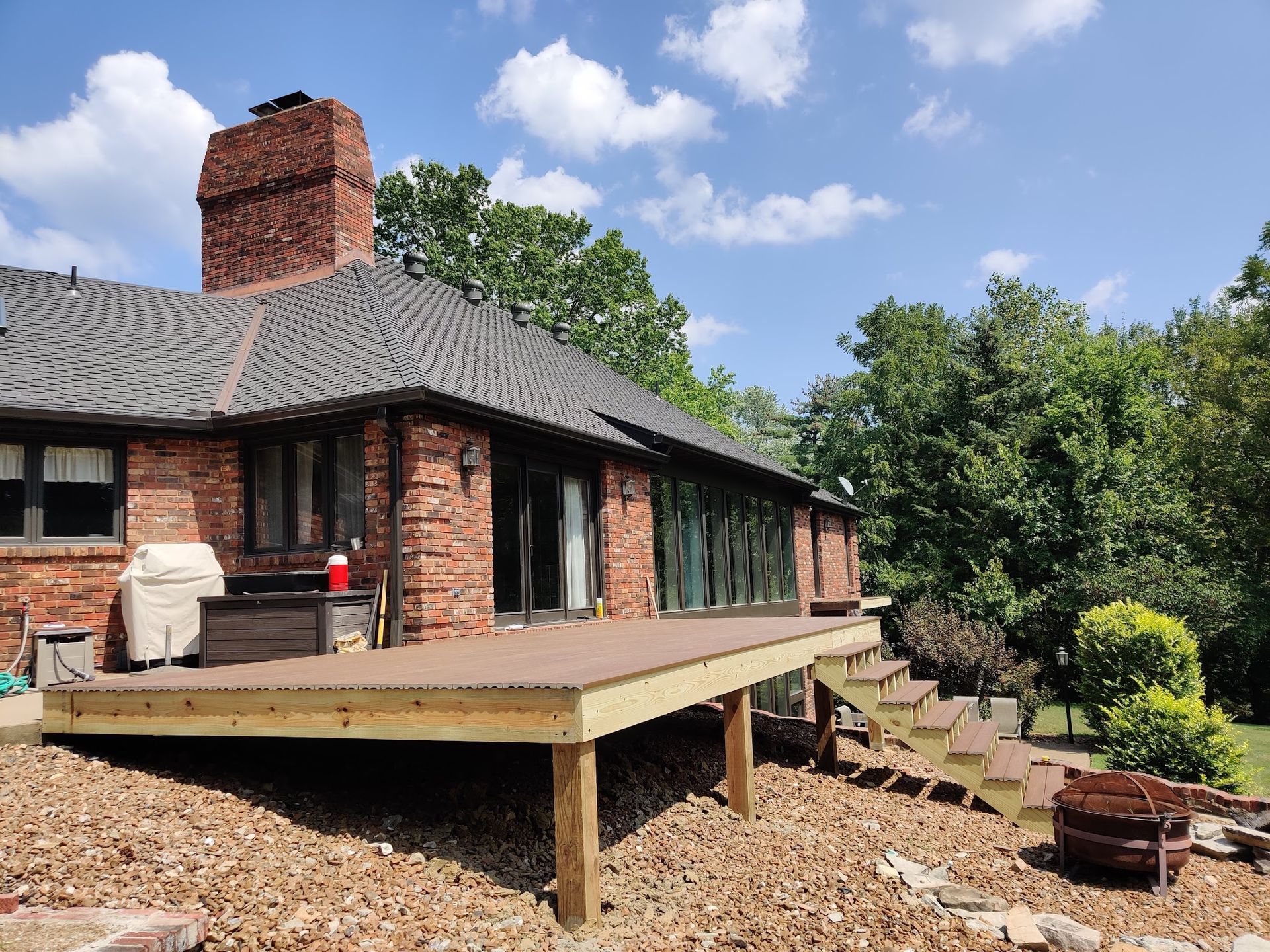 A large brick house with a wooden deck in front of it.