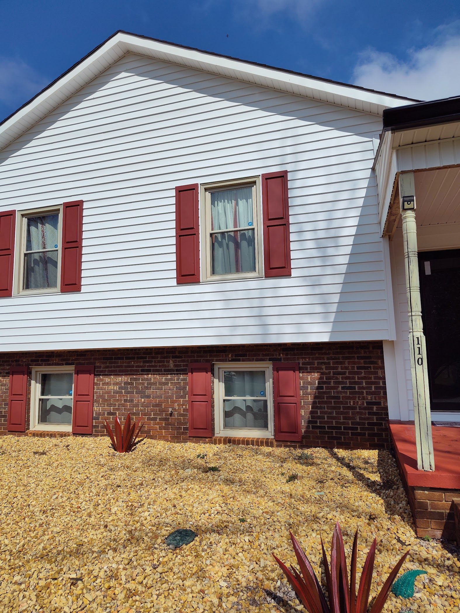 A white house with red shutters on the windows