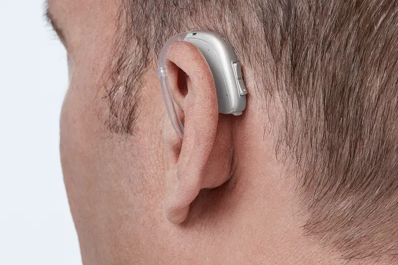 Close-up of ear with a gray hearing aid.