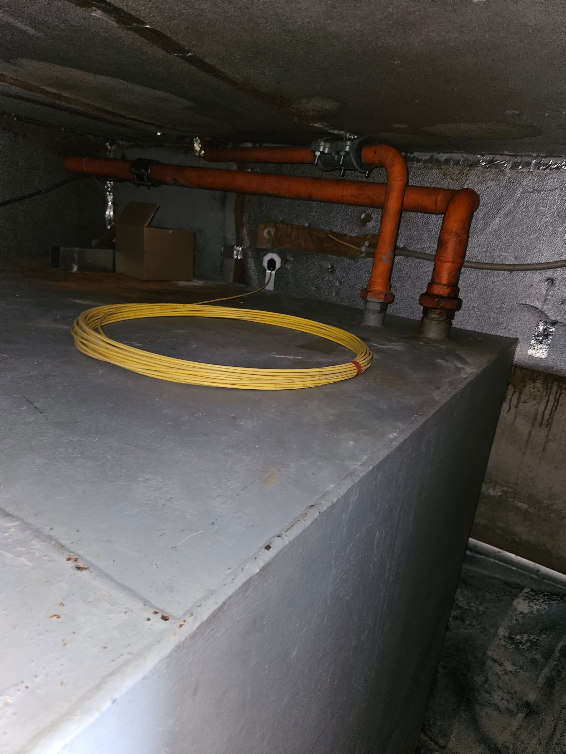 Une corde jaune est posée sur un réservoir en métal